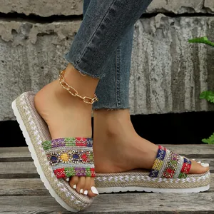 Detailed view of bohemian embroidered platform slides with woven jute midsole.