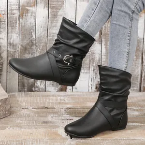 Detail view of black slouch mid-calf boots with stylish metal buckle and flat sole.