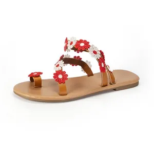 Detail of Bohemian flat sandals featuring exquisite red and white flower embroidery.