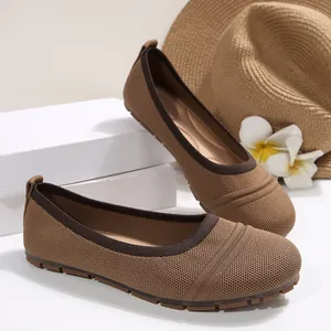 Detailed view of women's brown breathable knitted ballet flats in a summer setting