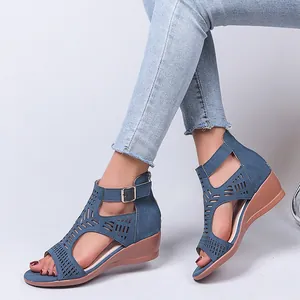 Stylish blue wedge sandals for women featuring geometric laser-cut details and buckle