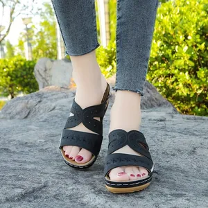 Vista detallada de sandalias con cuña bordadas negras para mujer usadas al aire libre