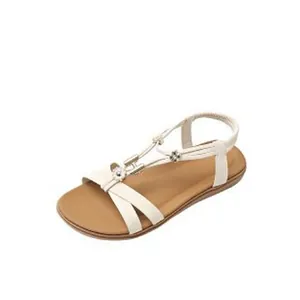 Close-up of white bohemian flat sandals with floral accents and H buckle decoration.