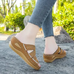 Primer plano de sandalias con cuña para mujer con detalles bordados florales