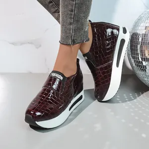 Vista dettagliata delle sneakers bordeaux effetto coccodrillo con suola platform da donna.