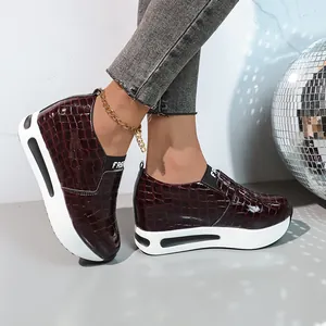 Vista laterale dettagliata di sneaker con zeppa interna e motivo coccodrillo bordeaux