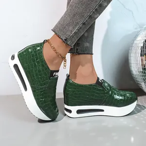 Vista laterale delle sneakers platform verdi da donna con trama a coccodrillo