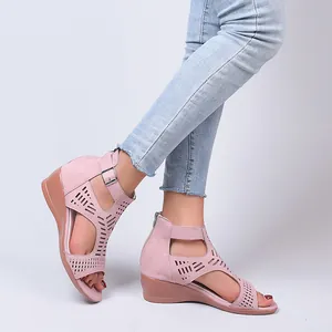 Elegant pink suede-like wedge sandals with laser-cut patterns and buckle ankle strap.