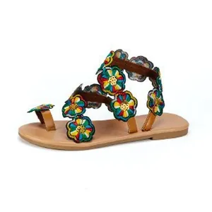 Detailed side view of bohemian flat sandals featuring colorful embroidered flower straps