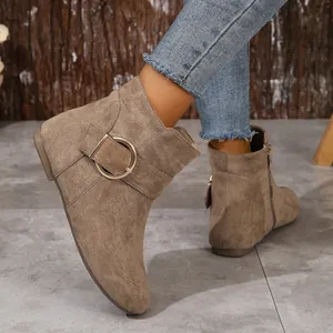 Detailed side view of khaki suede Chelsea boots with decorative gold buckle and zipper