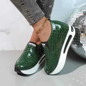 Dettaglio sneakers verdi con zeppa interna e trama coccodrillo e suola spessa per donna