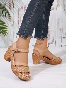 Close-up of nude block heel sandals with woven platform and buckle ankle strap.