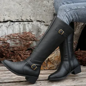 Detailed close-up of black leather knee-high knight boots featuring a buckle and zipper