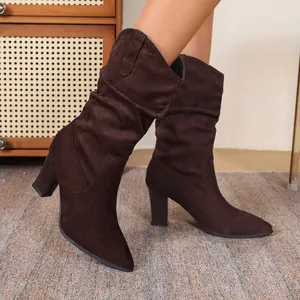 Detail view of brown suede slouch boots with block heels on model