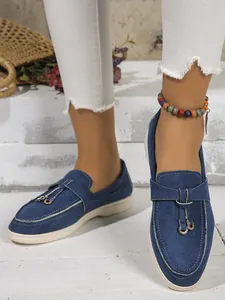 Close-up of vintage blue loafers for women featuring a retro slip-on design and flat sole