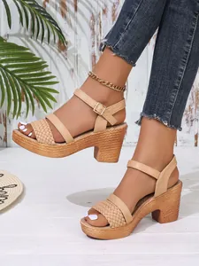 Close-up detail of stylish beige block heel sandals with woven platform and ankle strap