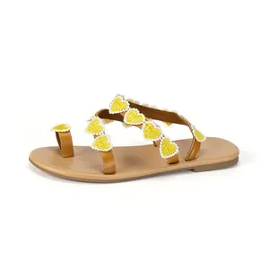 Bohemian flat sandals with brown straps and yellow heart-shaped lace details