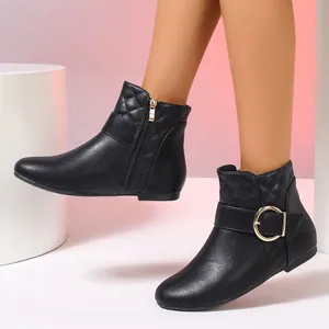 Close-up of black ankle boots featuring side zipper, quilted pattern and gold buckle