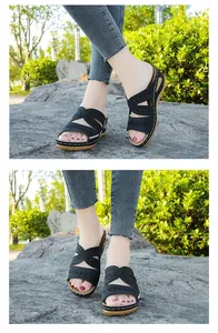 Vista detallada de sandalias de cuña bordadas para mujer en color negro con costuras.