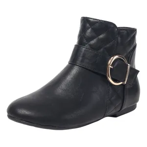 Detailed view of black Chelsea ankle boots with quilted texture and gold buckle decor
