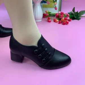 Side view of black mid-heel pointed toe women's shoes with decorative button details