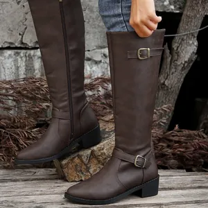 Detailed view of brown tall rider boots with side zipper and buckle accents