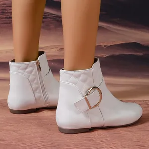 Stylish white quilted ankle boots featuring a decorative gold buckle and side zipper detail