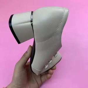 Detailed side view of the cream faux leather block heel boot with metallic accent