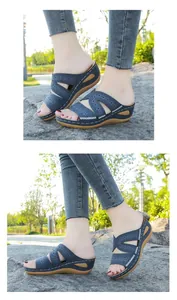 Vista lateral que muestra bordados florales intrincados en sandalias de cuña azules