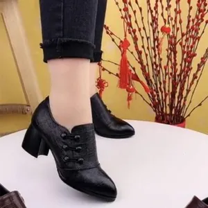 Black pointed-toe ankle boots with decorative buttons and block heels