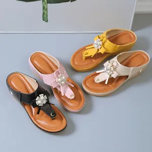 Vista detallada de sandalias de cuña para mujer con lazos de perlas en varios colores