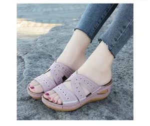 Detalle de sandalias de cuña para mujer moradas con delicados bordados florales y diseño calado