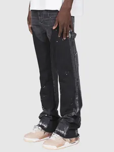 Gedetailleerd overzicht van zwarte denim timmermansbroek met witte verfspatten.