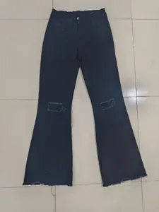 Detailansicht der schwarzen Schlagjeans für Damen mit Rissen und ausgefranstem Saum.