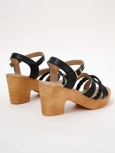 Side view of women's black platform sandals with braided straps and chunky wooden heel