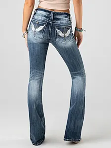 Back view of women's flared jeans featuring intricate wing embroidery on pockets.