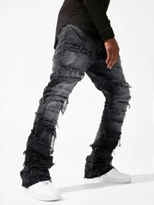 Detail view of men's distressed stacked denim jeans in modern streetwear style.