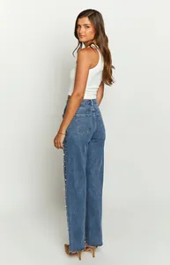 Detailed side view of baggy denim jeans featuring elegant pearl embellishments along seams