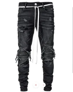 Detail view of black distressed biker jeans featuring ribbed knee panels and white belt