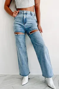 Vue détaillée d'un jean taille haute avec découpes aux cuisses ornées de strass et délavage.