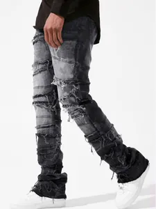 Detailed view of men's straight-leg grey jeans featuring patchwork and frayed edges.