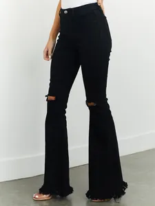 Detailansicht der schwarzen Stretch-Schlagjeans mit Rissen und Fransen am Saum
