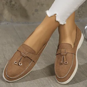 Close-up of brown suede loafers for women with decorative metal ring details