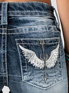 Close-up showing the heavy wing and arrow embroidery detail on denim back pocket