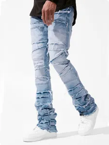 Detail view showing men's distressed stacked jeans with patchwork denim and frayed edges