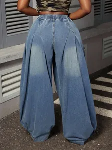 Back view of oversized washed blue denim lantern pants with pleated details