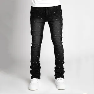 Detailed view of men's black stacked jeans featuring sparkling rhinestone studs