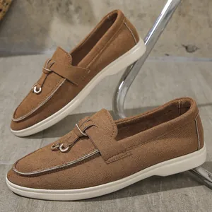 Detailed view of brown suede loafers with white flat sole and metal ring ornament