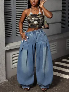Detail view of vintage washed blue pleated wide-leg lantern jeans with high waist