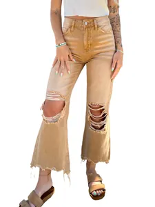 Detailed view of women's khaki distressed denim jeans with ripped knees and frayed hems